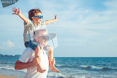 Image of Father and son playing on the beach at the day time.