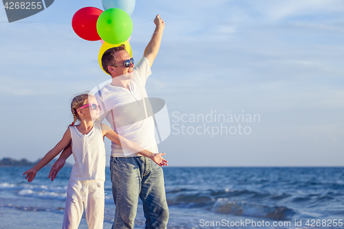 Image of Father and daughter playing on the beach at the day time.