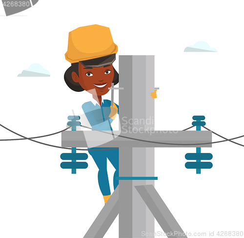 Image of Electrician working on electric power pole.