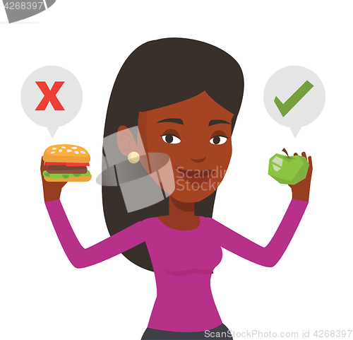 Image of Woman choosing between hamburger and cupcake.