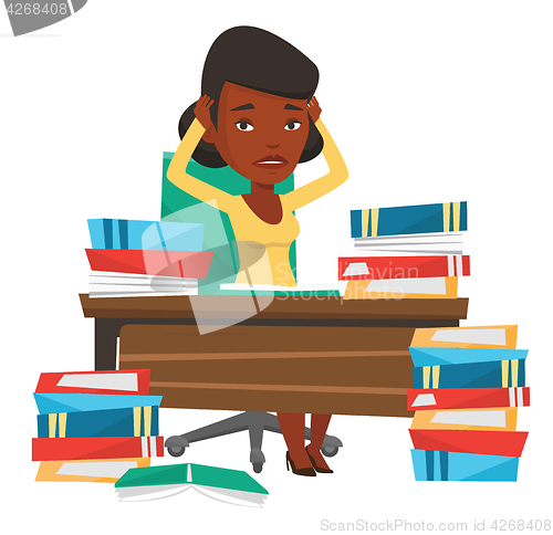 Image of Student sitting at the table with piles of books.