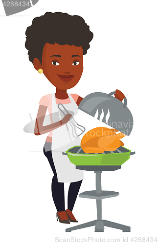 Image of Woman cooking chicken on barbecue grill.