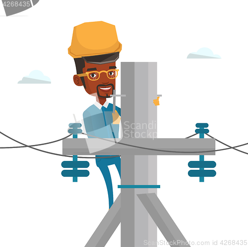 Image of Electrician working on electric power pole.