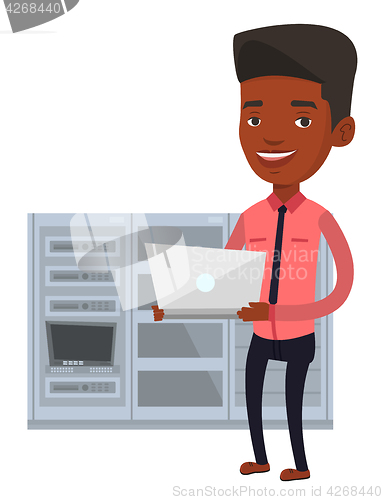 Image of Engineer working on laptop in network server room.