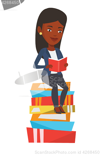 Image of Student sitting on huge pile of books.