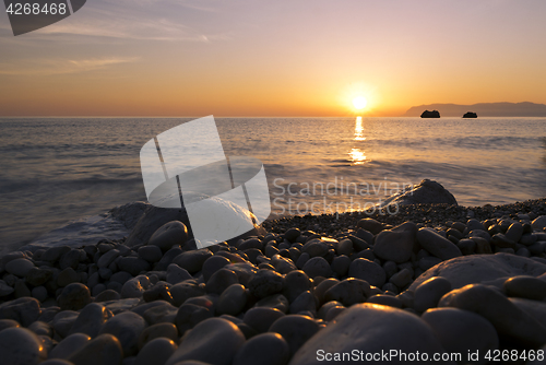 Image of Sunrise, sea and pebble beach