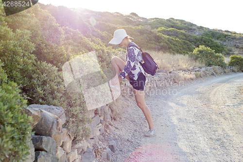 Image of Young woman whith white hat tying shoelace