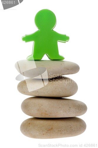 Image of Green figurine on a stack of pebbles