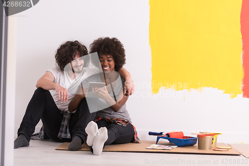 Image of young multiethnic couple relaxing after painting