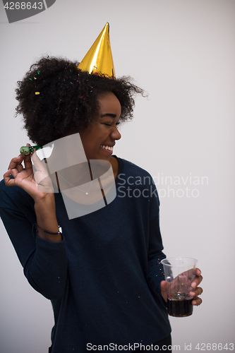 Image of black woman in party hat blowing in whistle