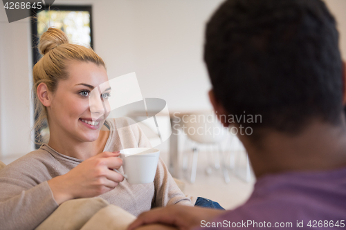 Image of Young multiethnic couple  in front of fireplace
