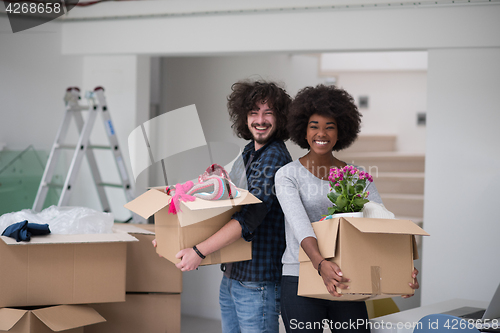 Image of multiethnic couple moving into a new home