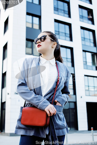 Image of young pretty brunette business woman posing against modern building, lifestyle people concept