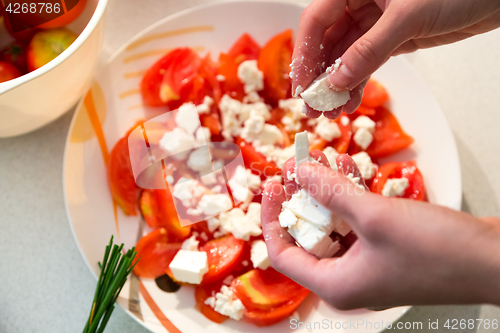 Image of Making of tomato salad with feta cheese.