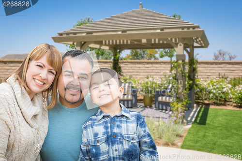 Image of Mixed Race Family In Back Yard Near Patio Cover.