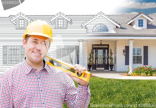 Image of Male Contractor Wearing Hard Hat In Front of House Drawing Grada