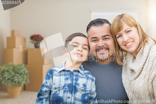Image of Mixed Race Family In Empty Room With Moving Boxes and Plants.