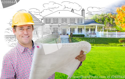 Image of Male Contractor Wearing Hard Hat In Front of House Drawing Grada