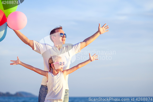 Image of Father and daughter playing on the beach at the day time.