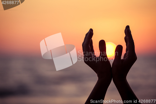 Image of silhouette of female hands during sunset