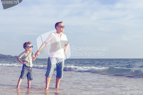 Image of Father and son playing on the beach at the day time.