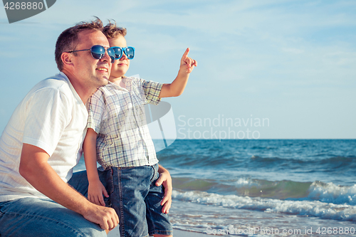 Image of Father and son playing on the beach at the day time.