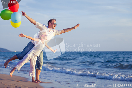 Image of Father and daughter playing on the beach at the day time.