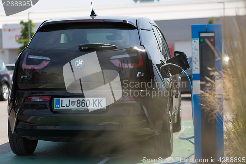 Image of i3 BMW electric car being charged at electric car charging station.