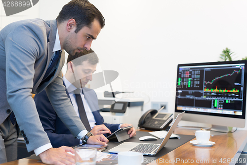 Image of Business team remotely solving a problem at business meeting using laptop computer and touchpad.