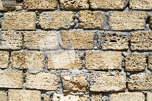 Image of wall from a rough yellow brick. background