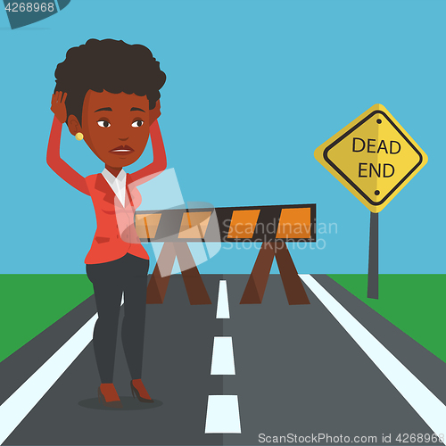 Image of Business woman looking at road sign dead end.