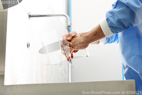Image of The doctor disinfects  his hands. Surgeon washing hands.