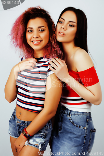 Image of lifestyle people concept: two pretty stylish modern hipster teen girl having fun together, diverse nation mixed races, happy smiling making selfie closeup