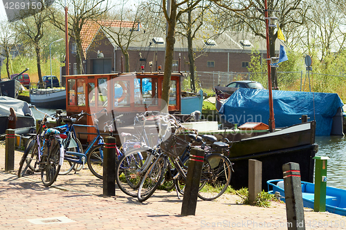 Image of Bikes and Traditional Dutch Botter Fishing Boats in the small Harbor of the Historic Fishing Village in Netherlands.