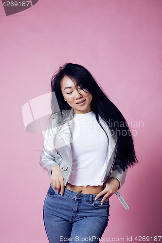 Image of young pretty smiling asian korean girl wearing modern fashion clothers on pink background, lifestyle people concept