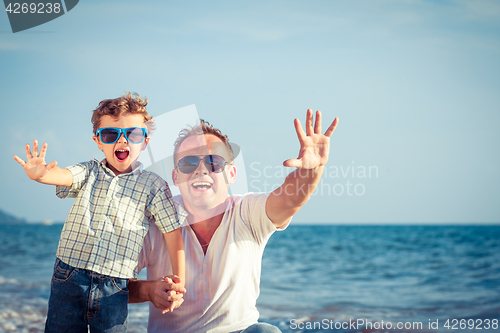 Image of Father and son playing on the beach at the day time.