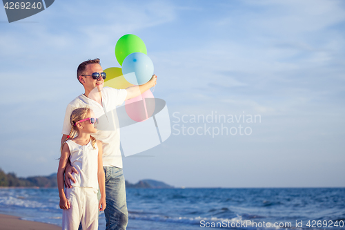 Image of Father and daughter playing on the beach at the day time.