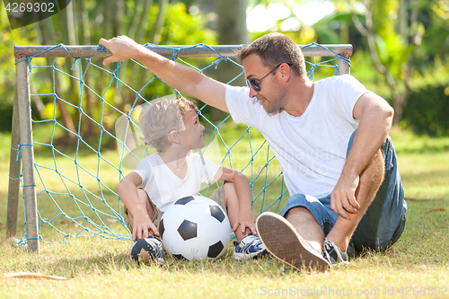 Image of Father and son playing in the park  at the day time.