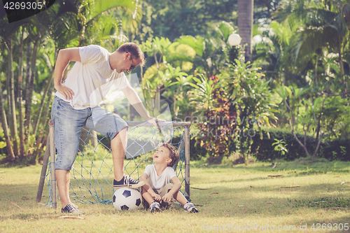 Image of Father and son playing in the park  at the day time.