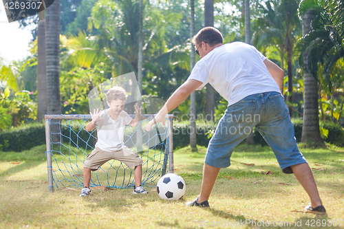 Image of Father and son playing in the park  at the day time.