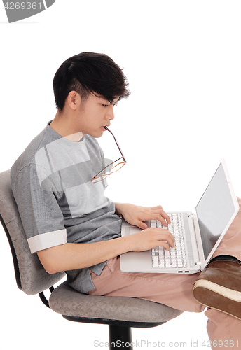 Image of Asian man working at his laptop.