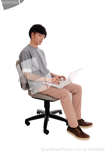 Image of Asian man typing at his laptop.