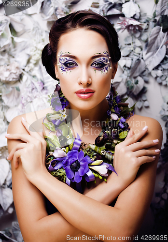 Image of floral face art with anemone in jewelry, sensual young brunette 