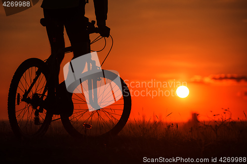 Image of Silhouette of a bike on sky background during sunset