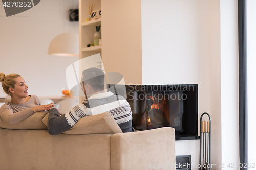 Image of Young couple  in front of fireplace
