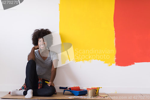 Image of back female painter sitting on floor