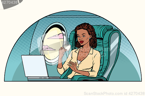 Image of African Businesswoman in business class of the aircraft works at