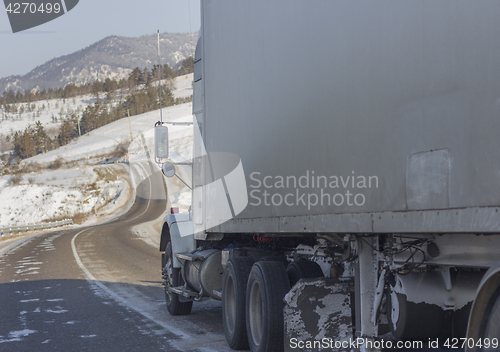 Image of Speeding truck wheels on icy road during winter storm