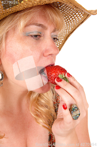 Image of Closeup of woman eating strawberry.