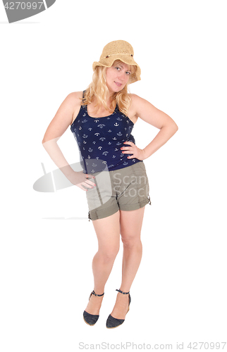 Image of Woman standing in shorts and straw hat.